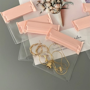 Detailed view of clear jewelry storage bags with pink zip lock for earring protection