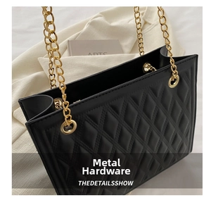 Detail of metal grommet and gold chain strap on black quilted diamond pattern bag