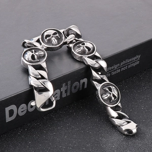 Detail of vintage silver punk Cuban chain bracelet with 22mm skull charms on a black box