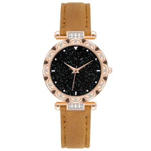 Detailed macro of a rose gold floral bezel watch with a black starry sky dial and stones