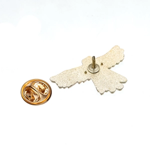 Detail view of the golden eagle metal badge reverse side with butterfly clutch pin backing