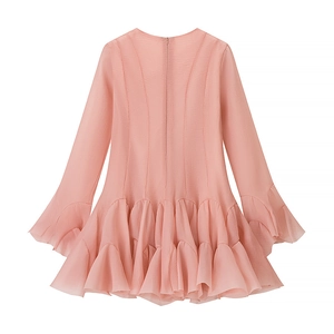 Detail of pink long sleeve dress with layered ruffle hem and pleated chiffon texture