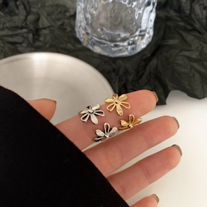Detail shot of elegant hollow flower open ring worn on hand with minimalist aesthetic