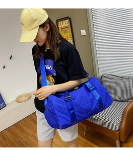 Blue large capacity duffel bag with patterned fabric and adjustable shoulder strap