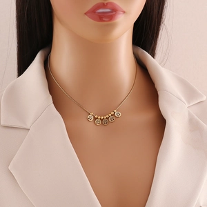 Golden Tree of Life beaded necklace displayed on a mannequin neck with a beige blazer