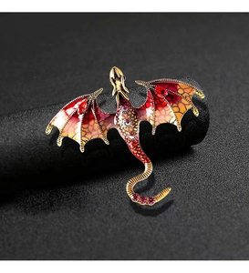 Detail view of the enamel dragon brooch with colorful scales and inlaid gemstones