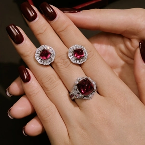 Detail view of S925 sterling silver ring and earrings set with red gemstone halo