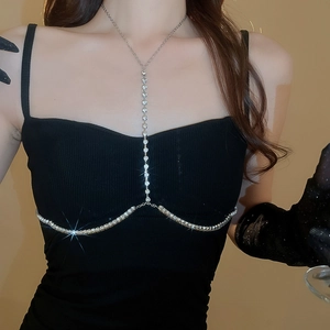 Dettaglio ravvicinato della catena per il corpo argentata con strass su una modella in nero