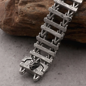 Macro detail of industrial steel chain bracelet featuring a fierce wolf head clasp