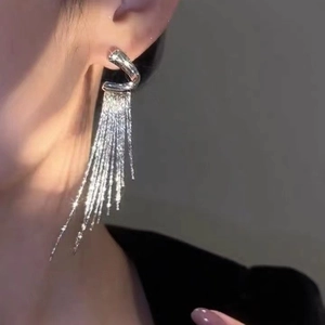 Elegant silver long tassel earrings with shimmering geometric design on model ear