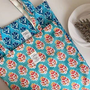 Detail of printed cotton tote bags showing floral patterns and decorative fabric labels