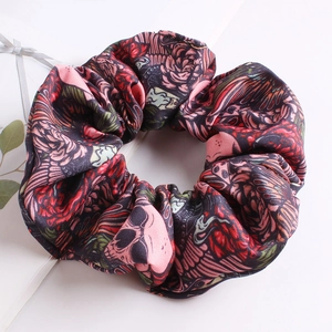 Detail of fabric scrunchie with skull, rose, and feather patterns for hair styling
