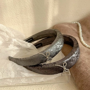 Elegant grey velvet headbands with silver beaded bows on a transparent acrylic display