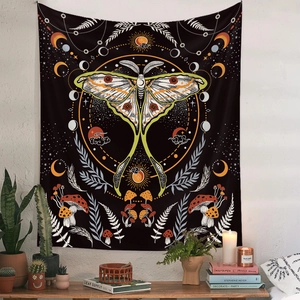 Bohemian moth tapestry with moon phases and mushrooms hanging on a white textured wall