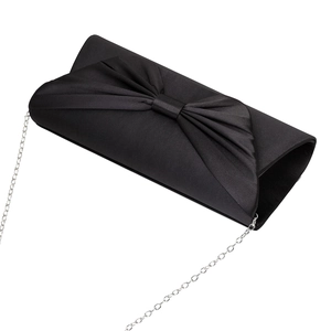 Macro detail of black satin evening bag with decorative bow and silver chain strap
