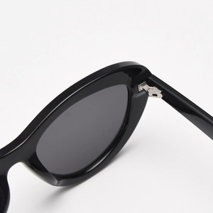 Detailed close-up of premium metal hinge and black frame on cat-eye polarized sunglasses