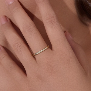 Minimalist 14K gold plated sterling silver ring shown on a model hand with soft lighting