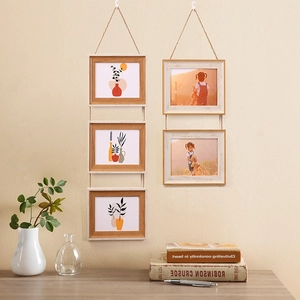 Hanging wooden multi-photo frames with jute rope and minimalist dual-tone frames on a wall