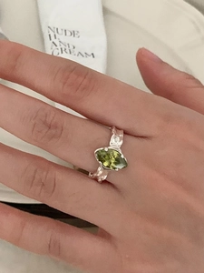 Detail of 925 sterling silver ring with olive green marquise zircon on hand