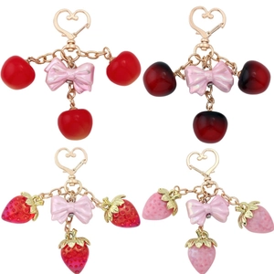 Fruit keychain set featuring red strawberries and cherries with pink bows and gold hearts