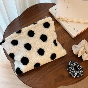 Detailed view of polka dot faux shearling cosmetic bag with matching hair scrunchies set