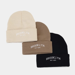 Three oversized ribbed knit beanies in beige, brown, and black with Brooklyn embroidery