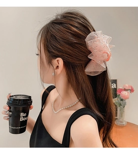 Détail d'une pince à cheveux en organza rose avec sequins pour demi-queue