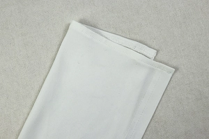 Close-up of double-needle stitching and fine knit texture on the white dress hem