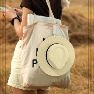 Beige lace travel hat clip for bags with metal spring hook on outdoor field background