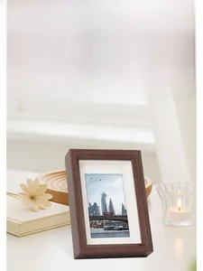 Detail of walnut wood photo frame with white matting and urban scenery in home setting