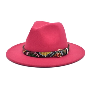 Detail of rose red fedora hat with snakeskin print band and golden metal buckle