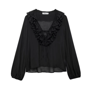 Detailed view of black chiffon blouse featuring a V-neckline with ruffled edges and ties