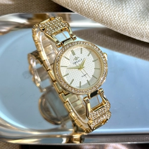 Vue détaillée de la lunette sertie de cristaux et du cadran doré de cette montre quartz