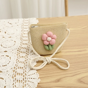 Detail of children's straw crossbody bag with pink floral decor and zip closure