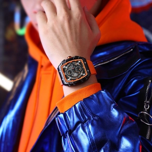 Close-up of sporty quartz watch with orange silicone strap and black multi-dial on wrist