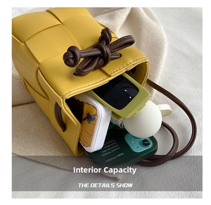 Detail view of woven yellow bucket bag showing interior space for mobile phone and items