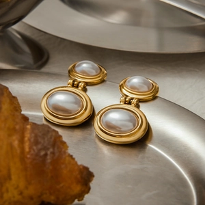 French vintage gold pearl earrings on a silver tray with a lifestyle breakfast background