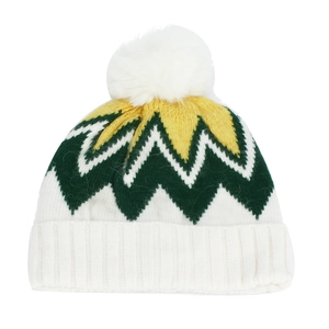 Détail du bonnet d'hiver en tricot avec motif zigzag vert, blanc, jaune et pompon blanc