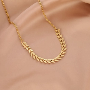 Elegant gold leaf necklace with realistic leaf texture on a luxurious satin background