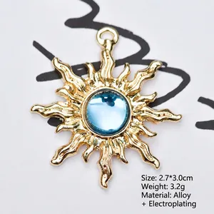 Macro detail of gold sunburst pendant with light blue faceted resin gemstone inlay