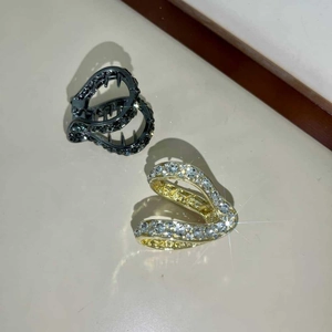Dettaglio ravvicinato delle mollette per capelli con strass lucidi in canna di fucile e oro