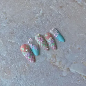 Custom press-on nails with 3D pink roses, blue accents, and pearl details on almond shape