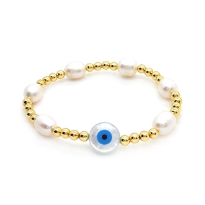 Baroque pearl bracelet with gold beads and a blue evil eye charm on white background