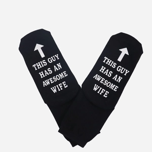Detail of black cotton socks with white lettering This Guy Has An Awesome Wife on the sole