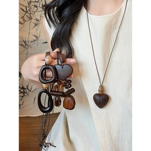 Macro detail of dark brown resin wood geometric pendant on retro sweater necklace