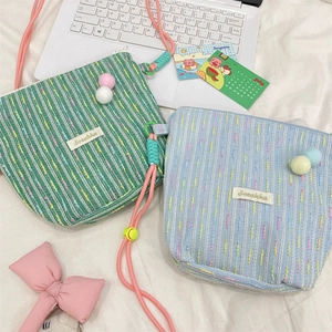 Detail of knitted crossbody phone bag with mint green stripes and cute colorful dots
