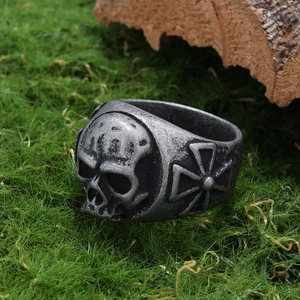 Macro detail of gothic skull ring with side iron cross engraving and oxidized silver finish