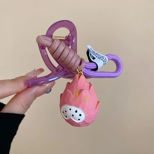 Detail of purple resin hair claw with woven cord and cute 3D dragon fruit pendant