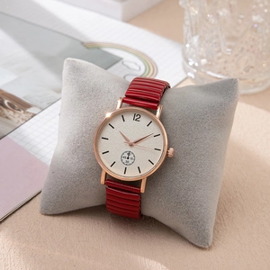 Détail de la montre or rose avec cadran blanc et bracelet flexible rouge sur velours