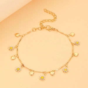 Détail des pendentifs marguerite et cœur dorés sur chaîne avec fermoir mousqueton